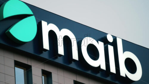Video - Chisinau, Moldova - October 1, 2025: Modern glass building facade with the illuminated maib logo