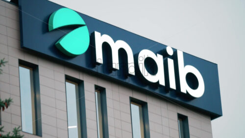 Video - Chisinau, Moldova - October 1, 2025: Modern glass building facade with the illuminated maib logo