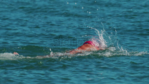 Video - Woman swimming freestyle in the calm turquoise water off the coast of Cannes, France