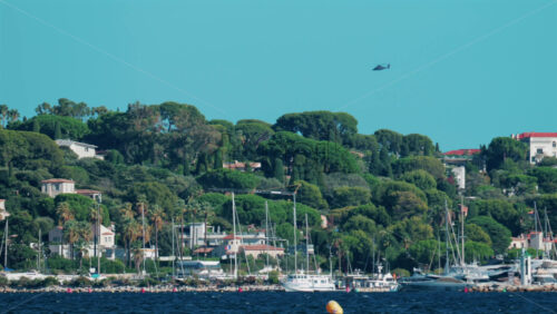 Video - Scenic view of yachts anchored near the lush green coastline and villas of Cannes, France