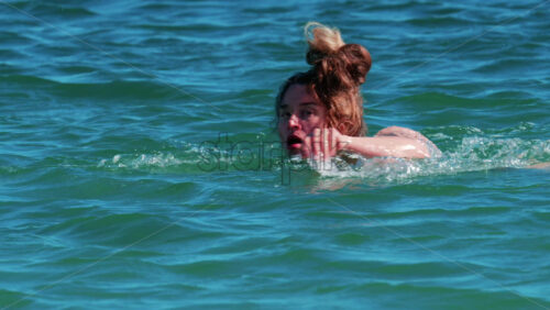 Video - A woman swims alone in the clear blue waters of the Mediterranean Sea near Cannes, France