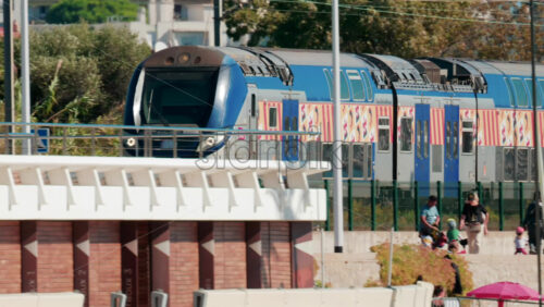 Video - Cannes, France - October 7, 2025: A train passes by a crowded beach as people relax by the sea