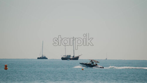 Video - Cannes, France - October 7, 2025: A sleek speedboat glides across the calm blue waters on a sunny day, leaving a gentle wake behind