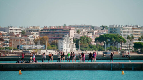 Video - Cannes, France - October 7, 2025: A group of people practicing dance or fitness on a pier by the sea on a sunny day