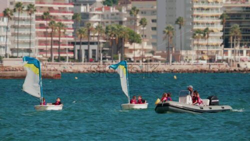 Video - Cannes, France - October 7, 2025: An instructor guides a group of children on a motorboat during a sailing lesson