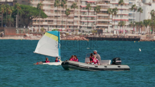 Video - Cannes, France - October 7, 2025: An instructor guides a group of children on a motorboat during a sailing lesson