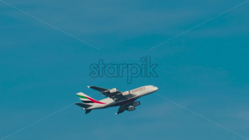 Video - Cannes, France - October 4, 2025: Emirates airplane flying across clear blue sky