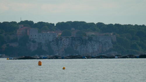 Video - View of a historic fortress and old buildings on top of white cliffs surrounded by dense green trees