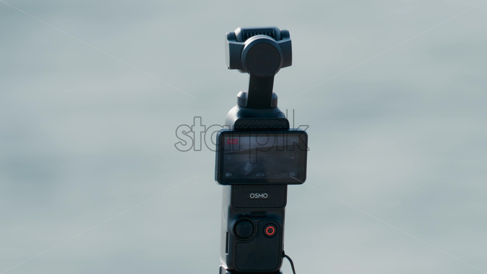 Video - Cannes, France - October 8, 2025: Close up of a small Osmo pocket camera recording by the sea, with the screen showing ocean waves