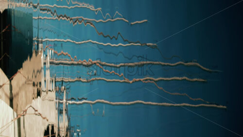 Video - Distorted reflections of yachts, ropes, and anchors on the glossy surface of a marina. Vertical