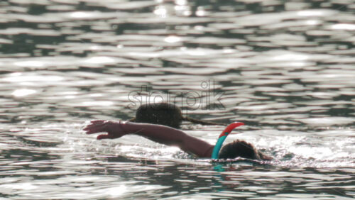 Video - Cannes, France - October 9, 2025: A woman prepares for snorkeling in the ocean, adjusting her mask while floating in gentle water under soft sunlight