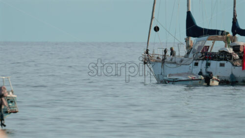 Video - Cannes, France - October 9, 2025: A surfer rides an electric foil board smoothly over the calm Mediterranean Sea near anchored boats