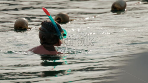 Video - Cannes, France - October 9, 2025: A woman snorkeling in the ocean, floating in gentle water under soft sunlight