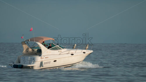 Video - Cannes, France - October 9, 2025: A white yacht sails smoothly across a calm sea during daylight, carrying a small group of people