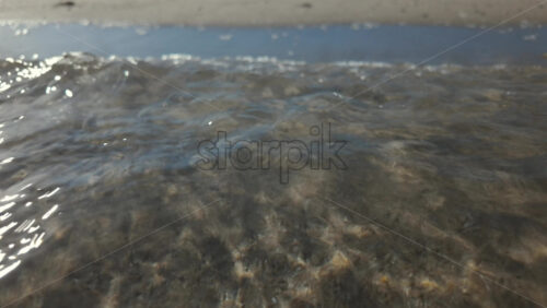 Video - Calm underwater view showing sand ripples and light reflections beneath the sea surface