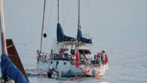 Video - Cannes, France - October 9, 2025: A weathered sailboat floats on calm waters, showing signs of age and rust