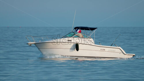 Video - Cannes, France - October 9, 2025: A sleek motor yacht glides across open waters under a clear blue sky