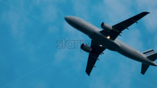 Video - Cannes, France - October 9, 2025: A passenger jet soars high in the sky with light clouds in the background