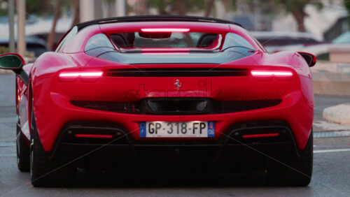 Video - Cannes, France - October 9, 2025: A red Ferrari sports car captured from behind, driving through the streets of the city