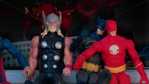 Video - Cannes, France - October 10, 2025: Colorful superhero action figures including Thor, Batman, and The Flash displayed in a shop window