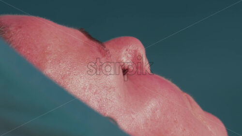 Video - Cannes, France - October 10, 2025: Extreme close up of a man's face resting under the sun, skin glistening in the heat