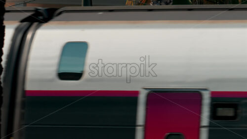 Video - Close up of a high speed train creating a motion blur effect with reflections on its windows