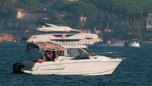 Video - Cannes, France - October 10, 2025: People enjoying a sunny afternoon aboard a white motorboat near the French Riviera coastline