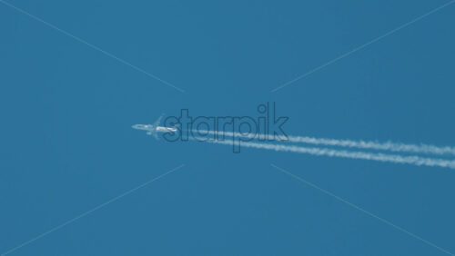 Video - Cannes, France - October 10, 2025: Airplane flying high above leaving long contrails in a clear blue sky