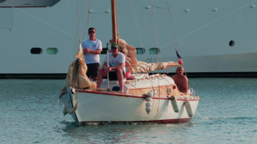 Video - Cannes, France - October 11, 2025: A white sailboat with two people onboard departs from the marina under a sunny sky