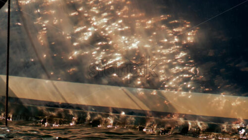 Video - Sunlight dances on the polished side of a luxury yacht, reflecting warm golden tones across gentle waves