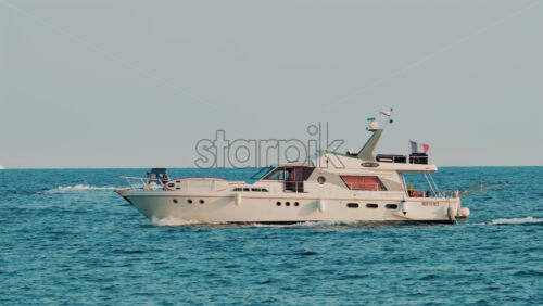 Video - Cannes, France - October 11, 2025: A modern white yacht cruises smoothly across the blue sea under clear skies