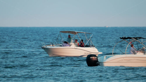 Video - Cannes, France - October 11, 2025: Two white boats pass close to each other on calm blue water, with people onboard enjoying the ride
