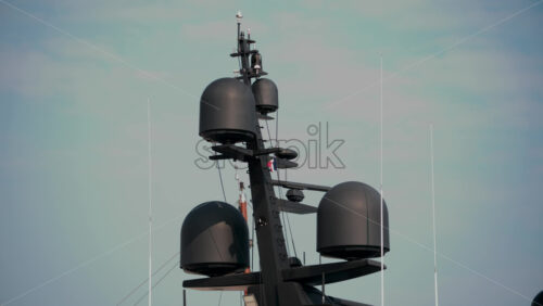Video - Close up of sleek black radar domes and antennas atop a modern superyacht