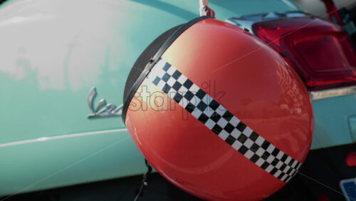 Video - Cannes, France - October 12, 2025: Detail shot of a mint green Vespa with an orange helmet featuring a checkered stripe