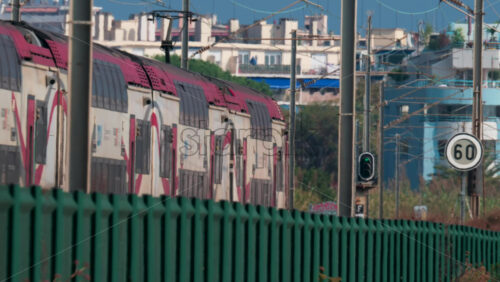 Video - A regional double decker train moves through the French Riviera landscape, framed by electric lines and vegetation