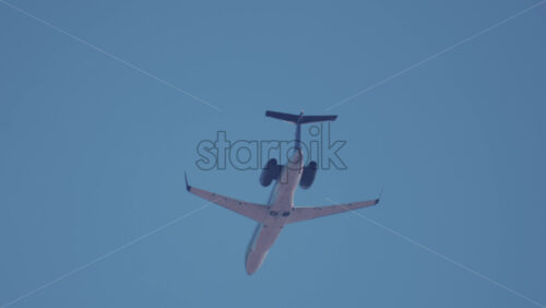 Video - A commercial airplane flying overhead with clear blue sky