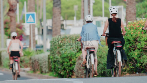 Video - People cycling through a palm-lined street in Cannes, France
