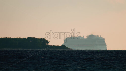Video - A large cruise ship sailing near the coast of Cannes, France, at sunset