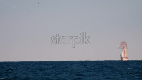 Video - A majestic sailing ship appears on the horizon against a pastel sky and deep blue sea
