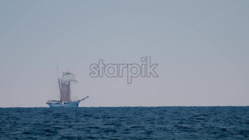 Video - A majestic sailing ship appears on the horizon against a pastel sky and deep blue sea
