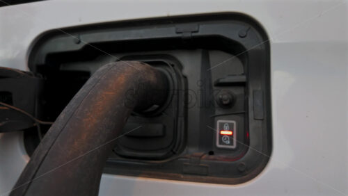 Video - Close up of an electric vehicle charging connector with illuminated green indicator lights