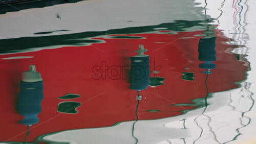 Video - Modern red and white yacht docked in calm marina waters with clear reflections