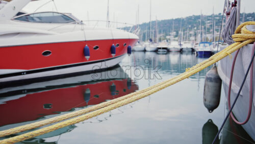 Video - Modern red and white yacht docked in calm marina waters with clear reflections