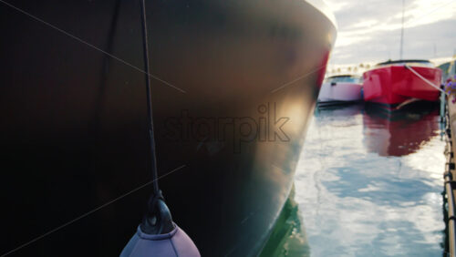 Video - Modern red and white yacht docked in calm marina waters with clear reflections