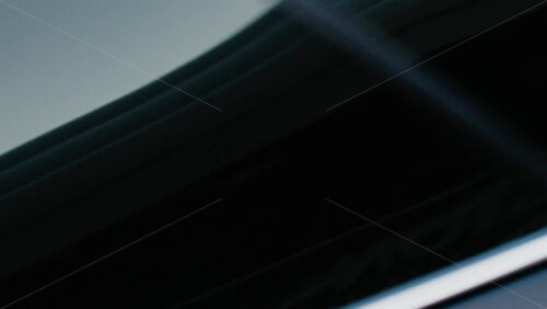 Video - Close up of a black sedan car moving on the street