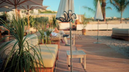 Video - Elegant sunbeds and umbrellas on a beach lounge in Cannes during golden hour