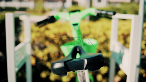 Video - Close up of a green electric bicycle with modern design, parked outdoors under natural light
