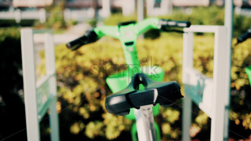 Video - Close up of a green electric bicycle with modern design, parked outdoors under natural light
