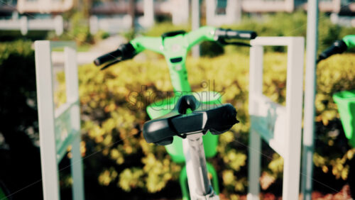 Video - Close up of a green electric bicycle with modern design, parked outdoors under natural light