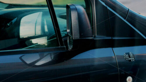 Video - Side view of a blue van showing mirror reflections of the road and sky